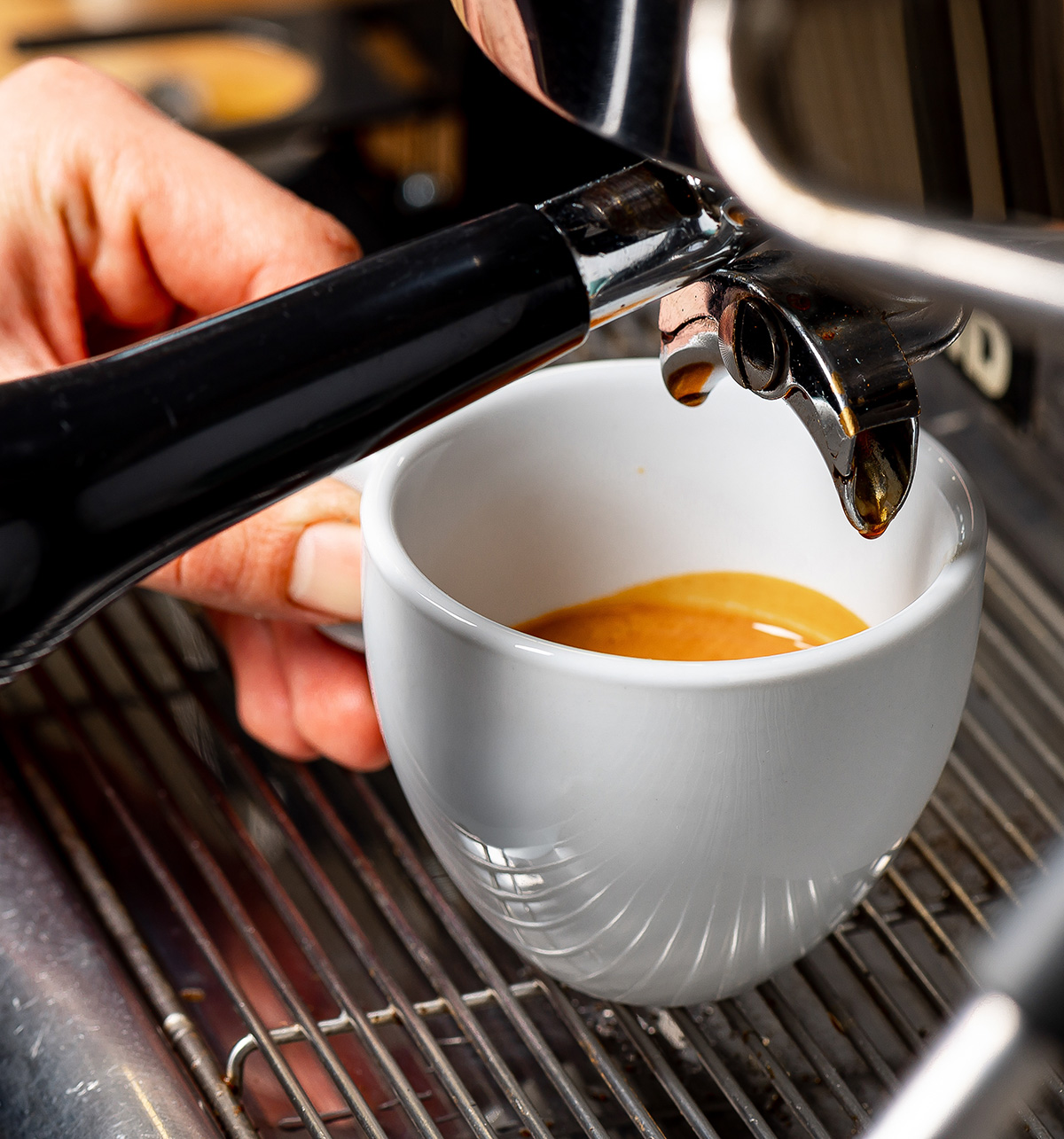 close up coffee machine on group head and coffee cup